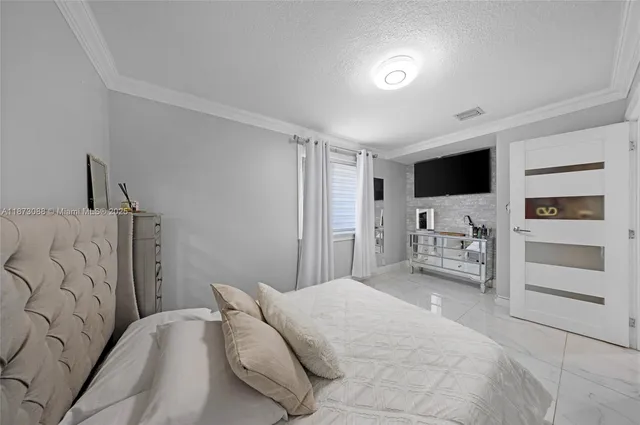 a bedroom with a bed and a television