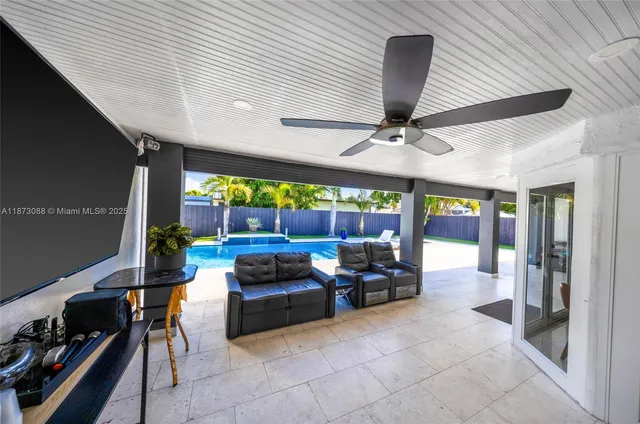 a living room with patio furniture and a ceiling fan