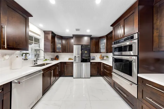 a large kitchen with stainless steel appliances lots of counter space a sink and cabinets