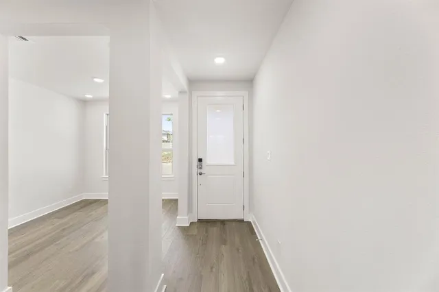 a view of a hallway with wooden floor