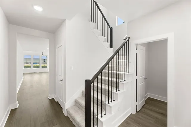a view of a hallway with wooden floor and entryway