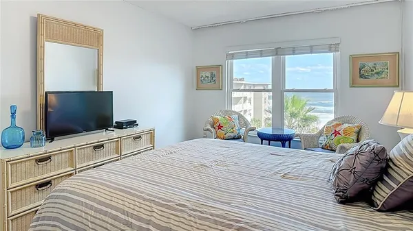 a bedroom with a bed and large windows