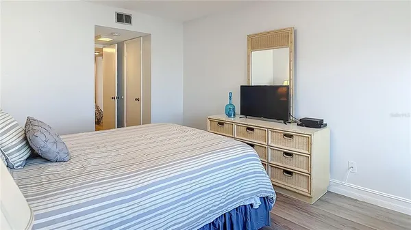 a bedroom with a bed and flat screen tv