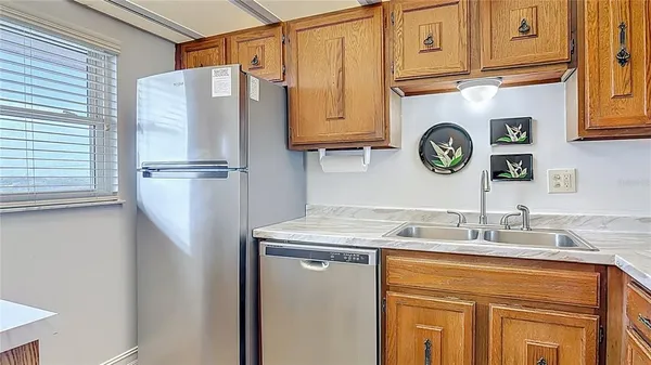 a kitchen with stainless steel appliances granite countertop a refrigerator a sink and dishwasher