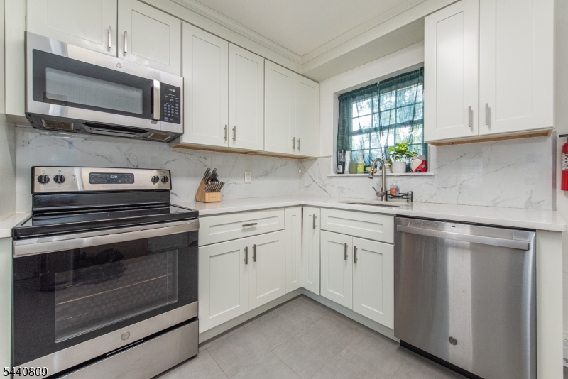 206 Main Street, Unit 42A Millburn, NJ 07041 - Photo 7 of 21 a kitchen with cabinets stainless steel appliances and window