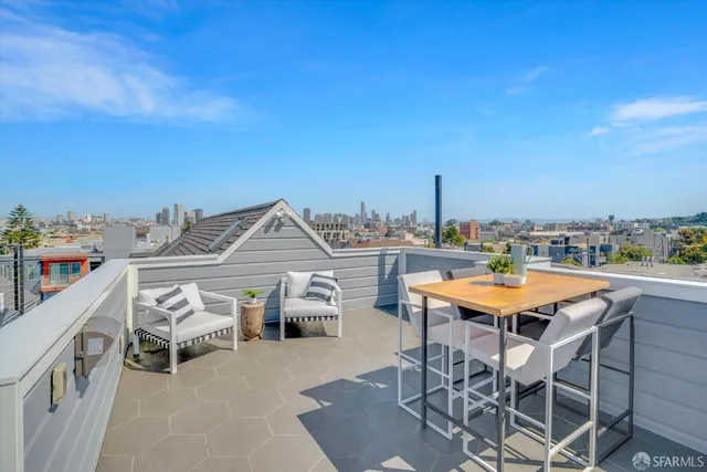 a view of a terrace with furniture and city view