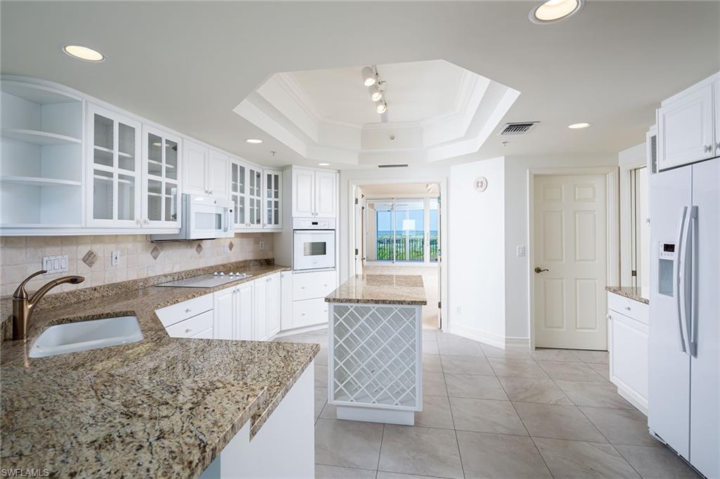435 Dockside Drive, Unit B703 Naples, FL 34110 - Photo 12 of 38 a large kitchen with kitchen island granite countertop a large counter top stainless steel appliances and cabinets
