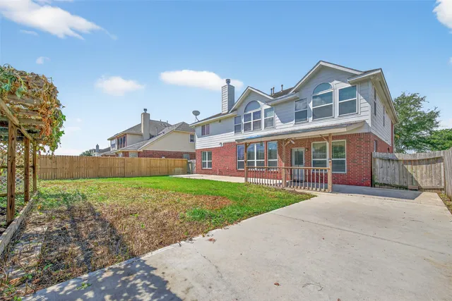 a view of a big house with a big yard and large trees