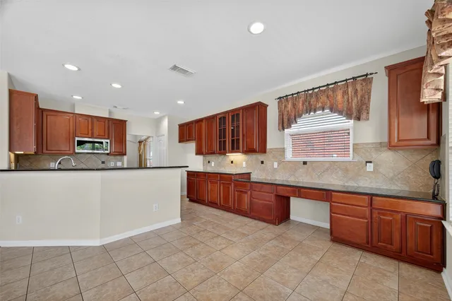 a large kitchen with stainless steel appliances granite countertop a large stove top oven a sink a dining table and chairs