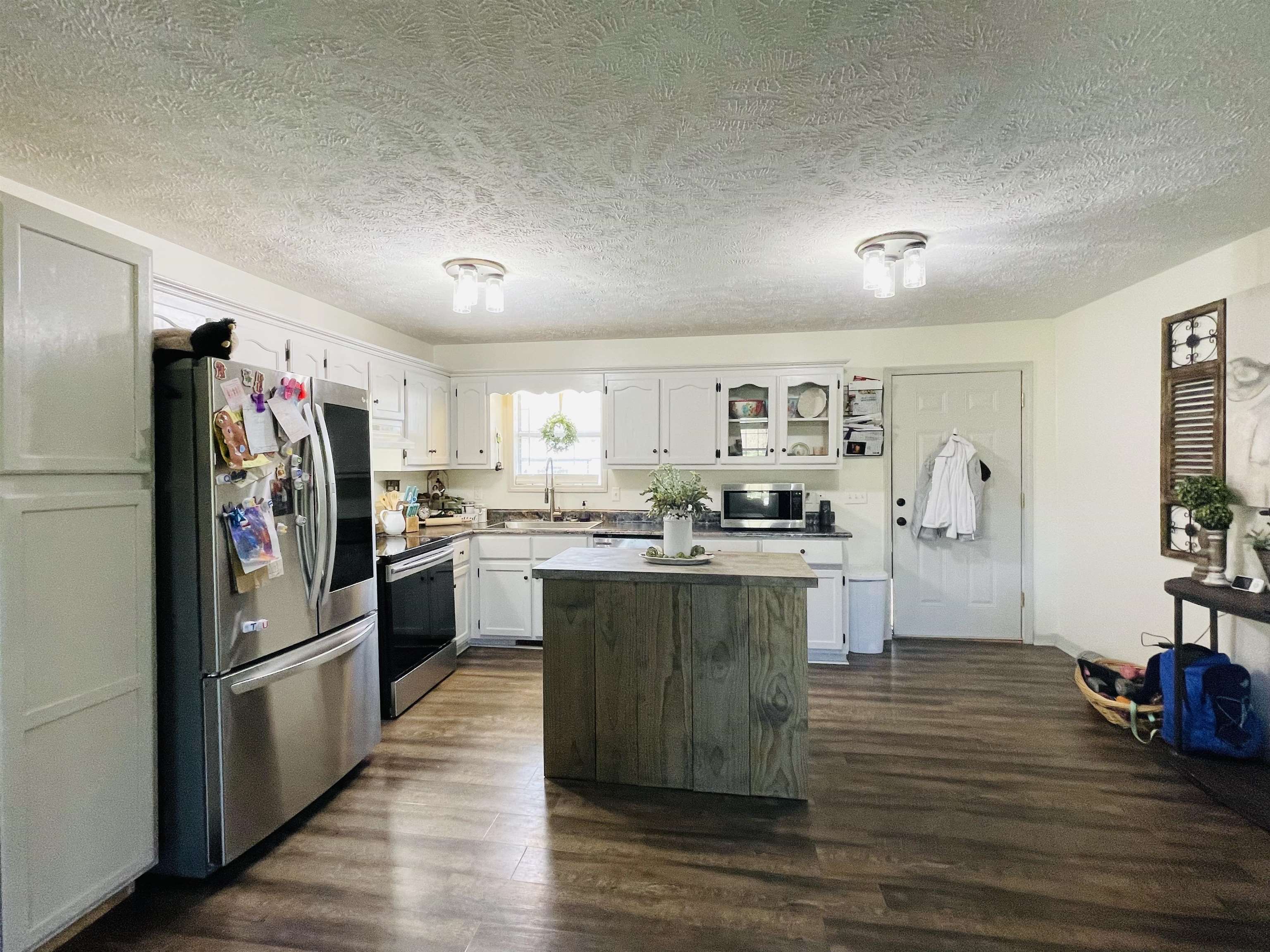 207 Chris Lane Ramer, TN 38367 - Photo 6 of 15 a kitchen with stainless steel appliances granite countertop a refrigerator a sink dishwasher a oven with white cabinets and wooden floor