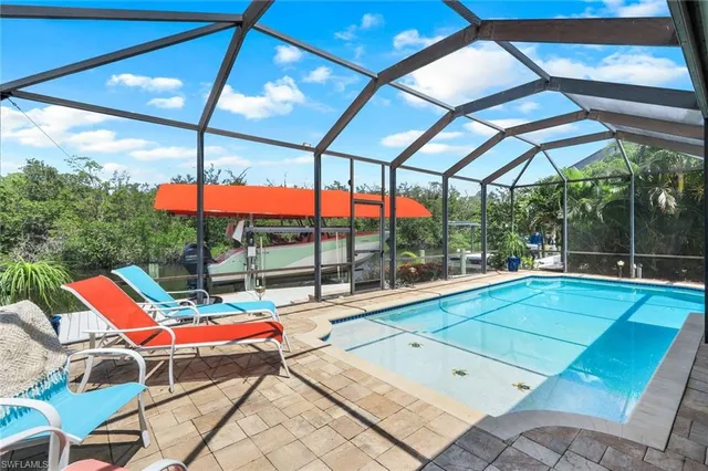 a backyard view of a patio with a dining table and chairs