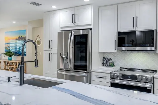 a kitchen with stainless steel appliances kitchen island granite countertop a stove and a sink with granite countertops