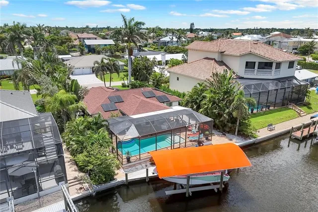 an aerial view of a house with swimming pool and outdoor seating