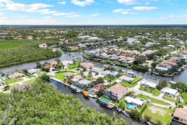 an aerial view of a city with lots of residential buildings ocean and mountain view in back