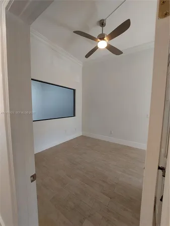 a view of an empty room and chandelier fan