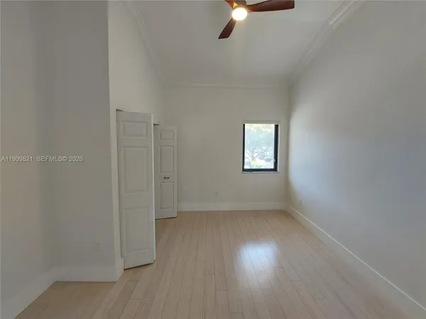 an empty room with closet and wooden door