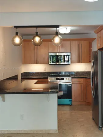 a kitchen with stainless steel appliances granite countertop a sink and a stove