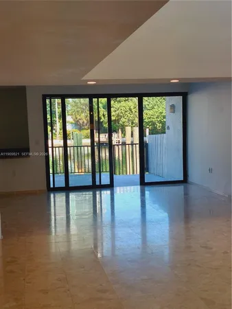 a view of empty room with wooden floor and floor to ceiling window