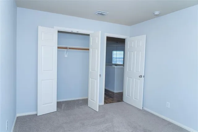 an empty room with closet and mirror