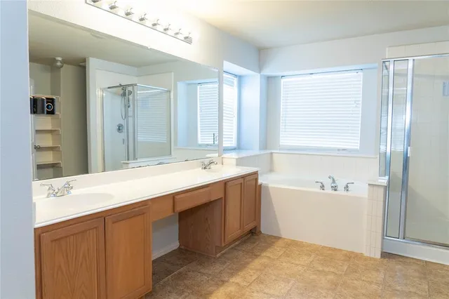 a spacious bathroom with a tub sink and mirror