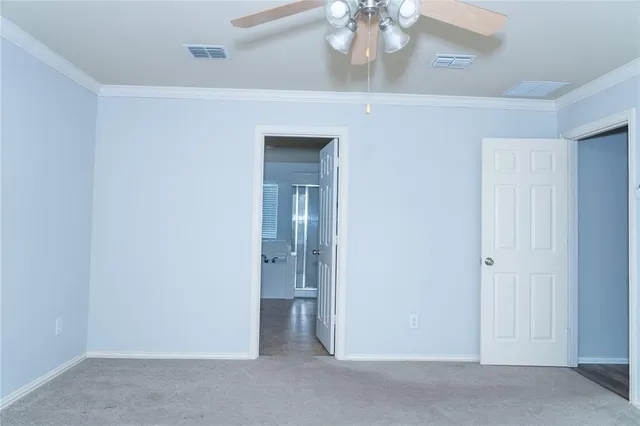 an empty room with a chandelier fan