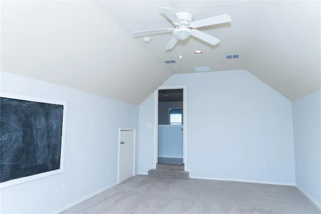 an empty room with chandelier fan