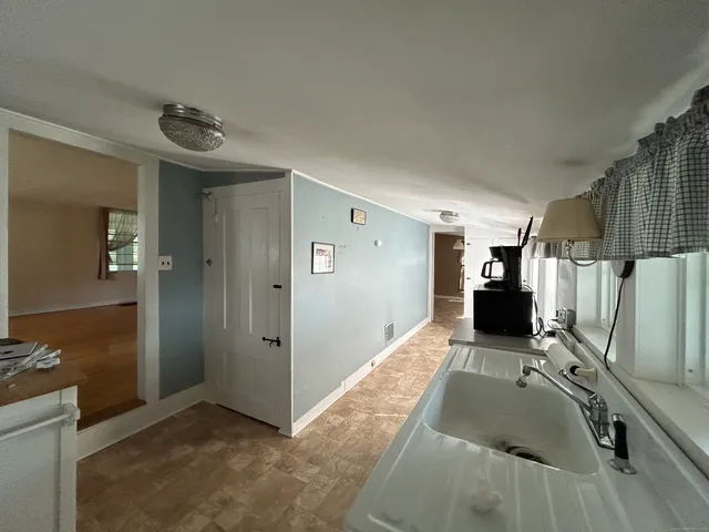 a view of a livingroom with wooden floor and a kitchen space