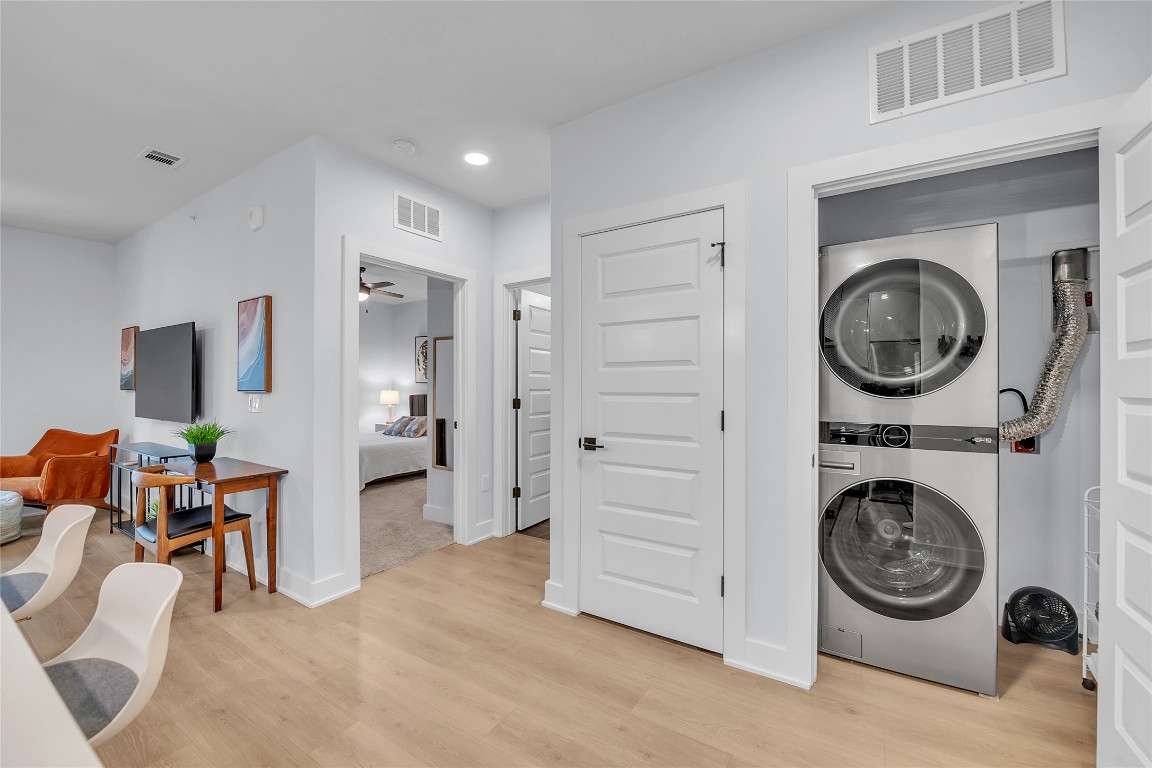 2500 Longview Street, Unit 217 Austin, TX 78705 - Photo 21 of 35 Laundry area with light wood finished floors, estacked washer and dryer, recessed lighting, and a ceiling fan