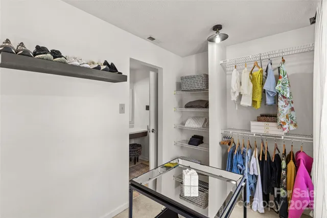 a view of walk in closet with clothes and shoes