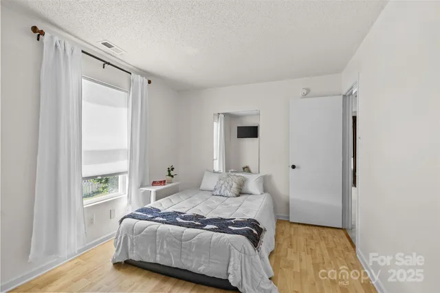 a bedroom with a bed and a window with the outer view