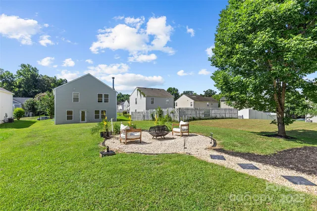 a backyard of a house with table and chairs