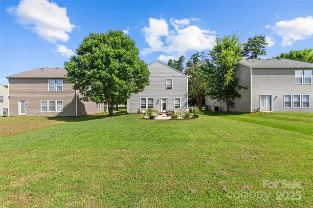 a view of a house with backyard and a tree