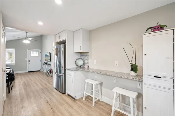 a kitchen with white cabinets and refrigerator