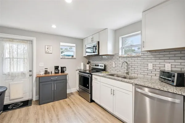 a kitchen with stainless steel appliances granite countertop a sink stove and refrigerator