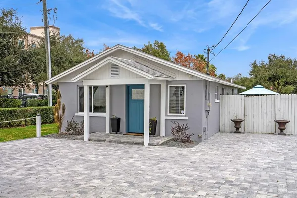 a view of a house with wooden fence next to a yard