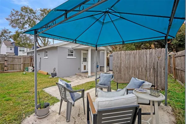 a patio with a table and chairs under an umbrella