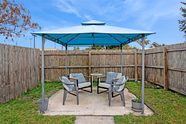 a chairs and table in the backyard with a fire pit