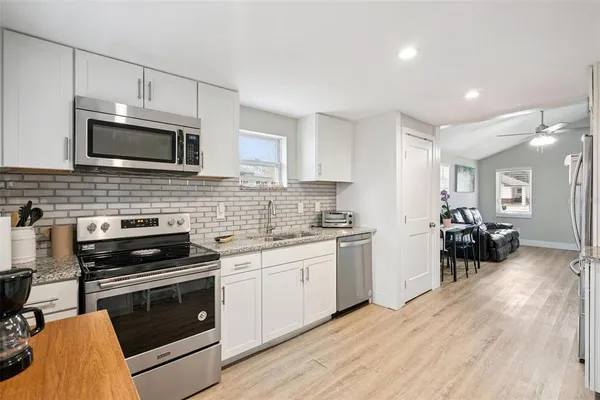 a kitchen with stainless steel appliances a stove sink microwave and cabinets