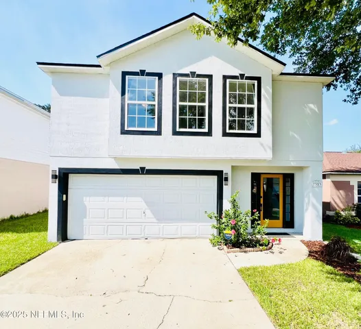 a front view of a house with a yard and garage