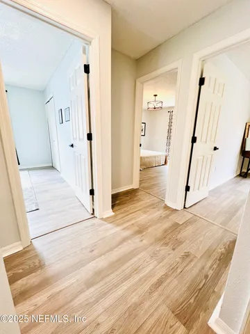 a view of a hallway with wooden floor and staircase