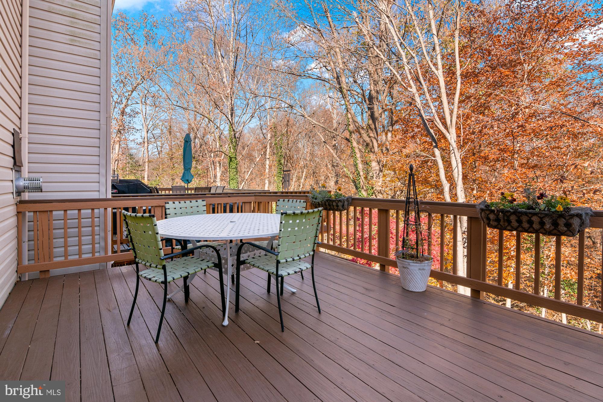 1447 Falcon Nest Court, Unit 45 Arnold, MD 21012 - Photo 56 of 58 a view of a roof deck with table and chairs a barbeque with wooden floor and fence