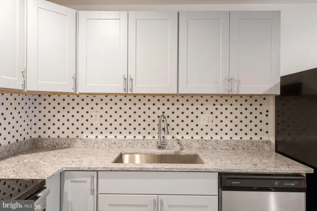 a bathroom with a granite countertop white and a sink