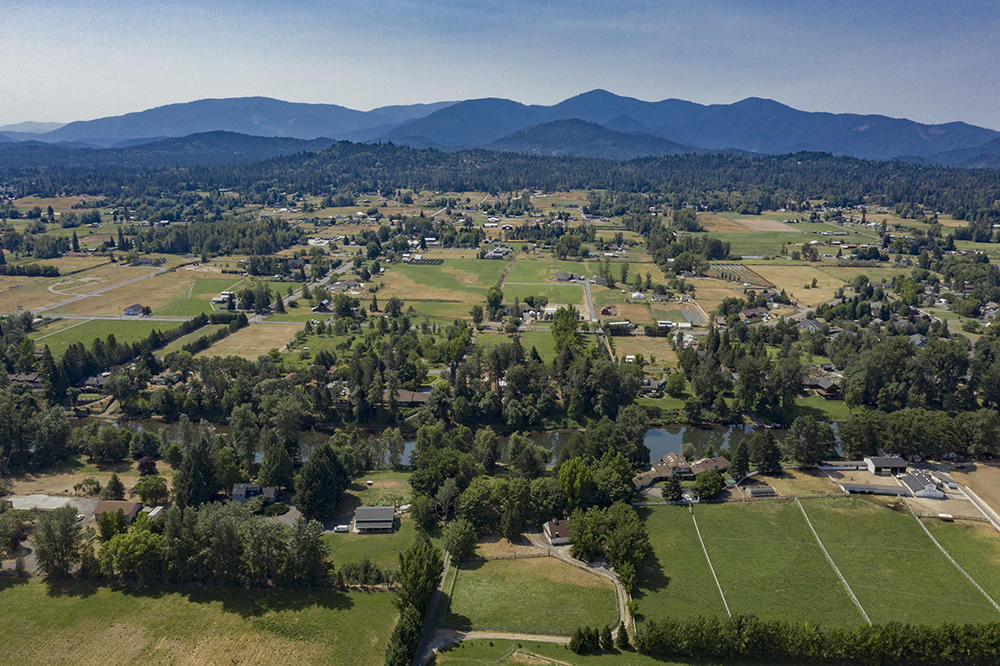 4028 Leonard Road Grants Pass, OR 97527 - Photo 18 of 26 a view of a lush green hillside and houses