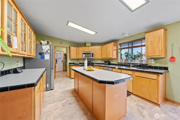 a kitchen with stainless steel appliances granite countertop sink stove top oven and cabinets