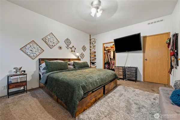 a spacious bedroom with a bed and a flat screen tv