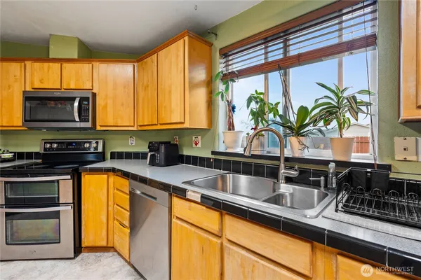 a kitchen with stainless steel appliances a sink a counter space and a window