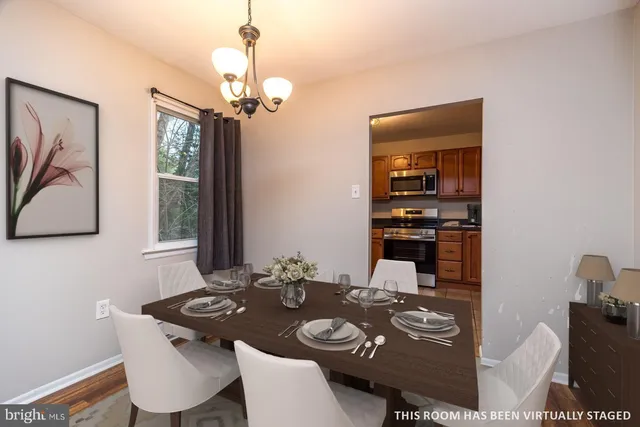 a view of a dining room with furniture a chandelier and wooden floor