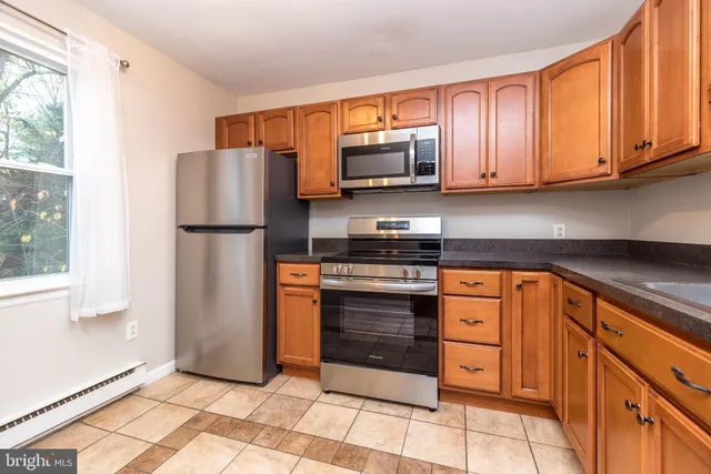 a kitchen with stainless steel appliances granite countertop a refrigerator stove and microwave