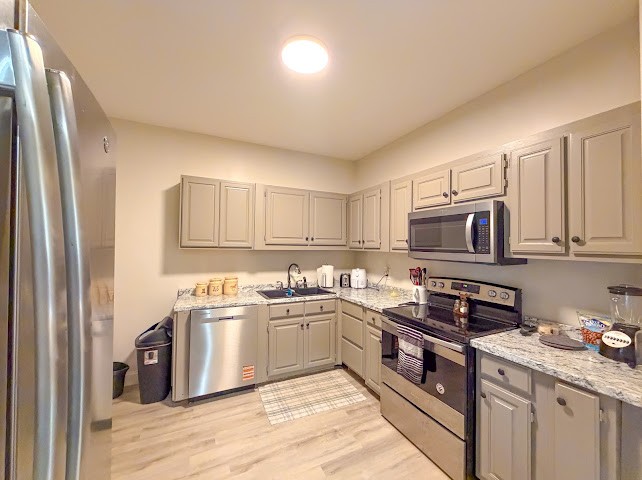449 Miller Lane Goodspring, TN 38460 - Photo 4 of 20 a kitchen with stainless steel appliances granite countertop a stove top oven a sink dishwasher and a refrigerator with wooden floor