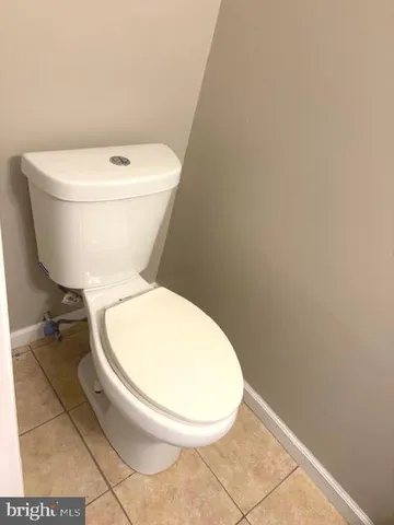a white toilet sitting next to a white wall